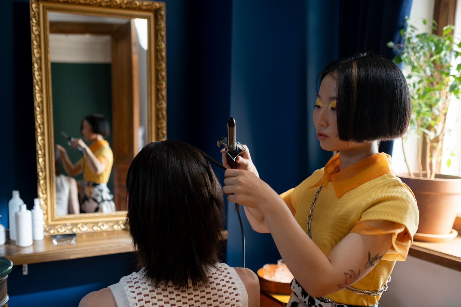 Hairdresser styling client's hair in a chic salon with a focus on detailed hair work