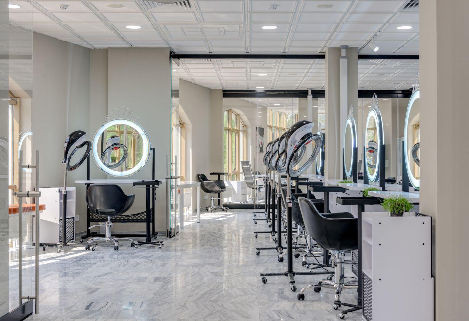 Bright and spacious hair salon interior featuring modern design elements and vanity mirrors