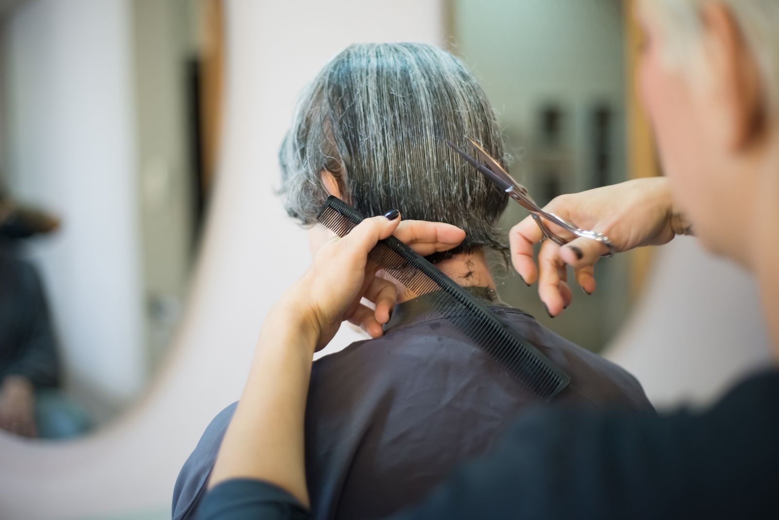 Close-up of a hairstylist cutting a client's hair in a salon